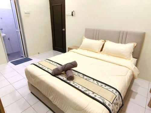 a bedroom with a bed with a towel on it at Lighthouse Tmn Intan 6pax Water Dispenser Neflix Target in Kluang