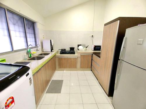 a kitchen with a sink and a refrigerator at Lighthouse Tmn Intan 6pax Water Dispenser Neflix Target in Kluang