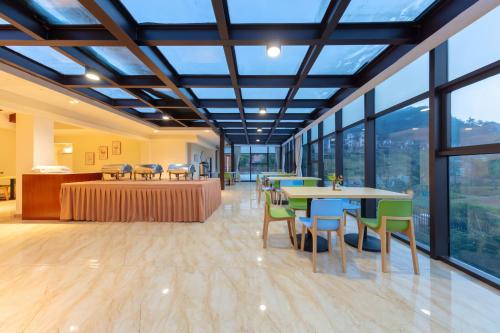 a large room with tables and chairs and windows at Avatar Valley Villas in Zhangjiajie