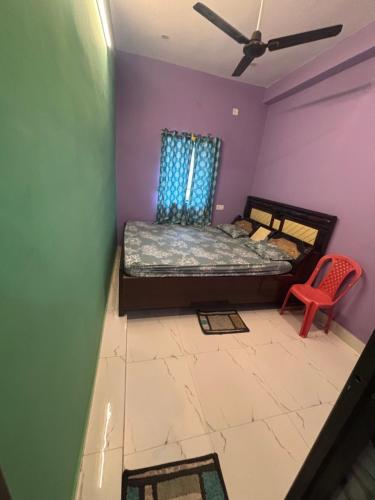 a bedroom with a bed and a red chair at Singh home stay in Bodh Gaya