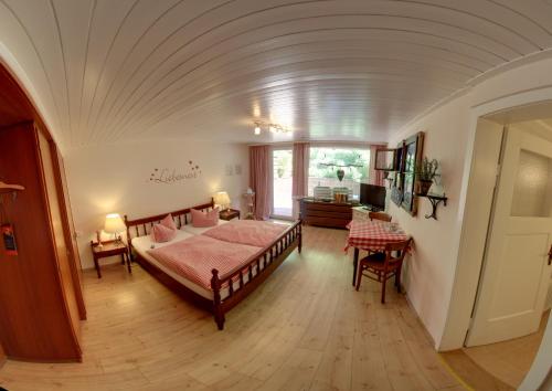 Hotel Merkurwald - Restaurant Wolpertinger في بادن بادن: غرفة نوم بسرير وطاولة في غرفة