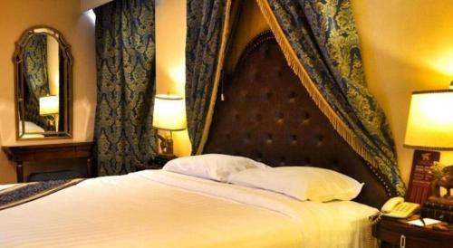 a bedroom with a bed and a phone and a mirror at Subic Bay Venezia in Olongapo