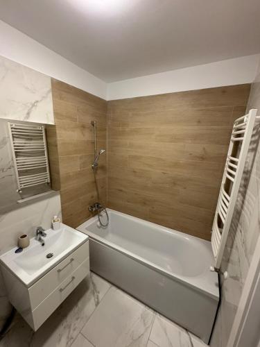 a bathroom with a white tub and a sink and a bath tub at Apartment in Ploiești 4 in Ploieşti