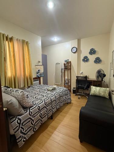 a bedroom with a bed and a desk and a chair at A Suburban Haven, top floor unit with Balcony- at Camarin Caloocan City!! in Camarin