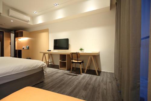 a hotel room with a desk and a television at Hai Sheng Wei B&B in Dahan