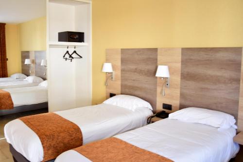 a hotel room with two beds in a room at Logis Des Sources in Cr&eacute;ney-pr&egrave;s-Troyes