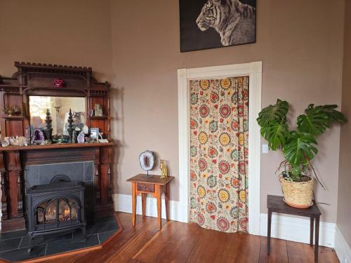 a room with a fireplace and a door with a plant at Charming Unique Themed Victorian Elegance in Eureka