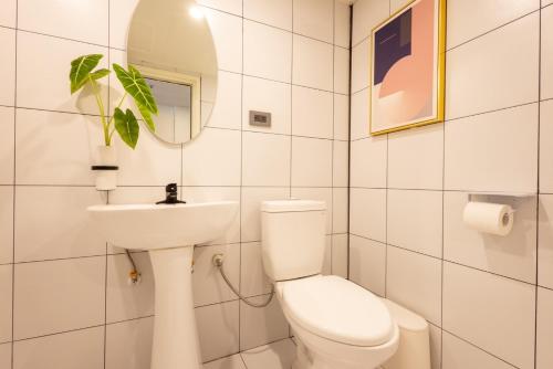 a white bathroom with a toilet and a sink at 樂居 台北 in T'ung-ko