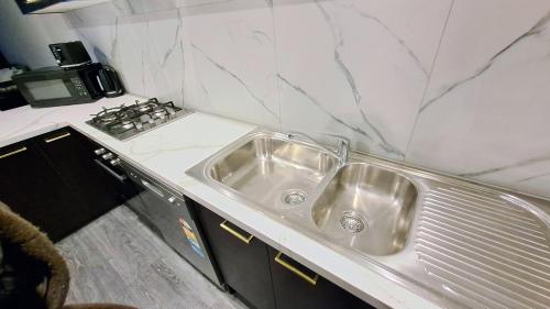 a kitchen with a sink and a stove at Exodus Dandenong Apartment Hotel in Dandenong