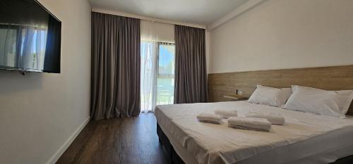 a bedroom with a large bed with two towels on it at Vila Luna in Vama Veche