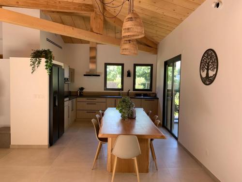 una cucina e una sala da pranzo con tavolo e sedie in legno di NEW Maison b Saint-Paul 8 Visiteurs a Saint-Paul-de-Vence
