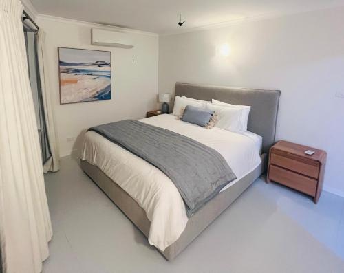 a bedroom with a large bed and a night stand at Eden Niu in Eden