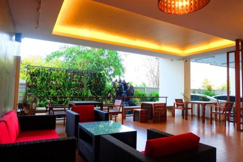 a restaurant with tables and chairs and a large window at The Pride in Nakhon Pathom