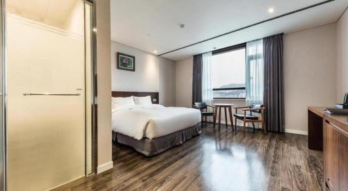 a hotel room with a bed and a table and chairs at CS Premier Hotel in Seoul