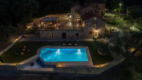 an aerial view of a house at night with a swimming pool at Villa Fabrica in Thimiá