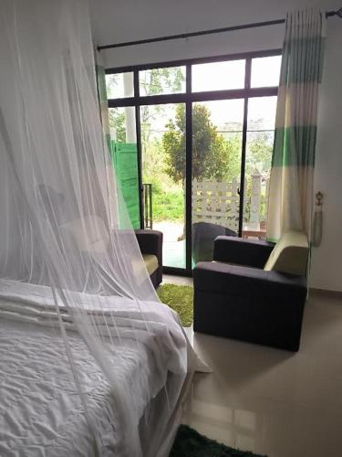 a bedroom with a bed and a couch and a window at White Elephant Ella in Ella