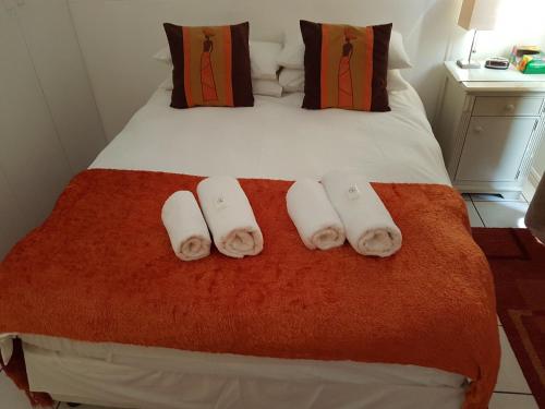 a hotel room with a bed with towels on it at Bradclin Sport Newlands in Cape Town