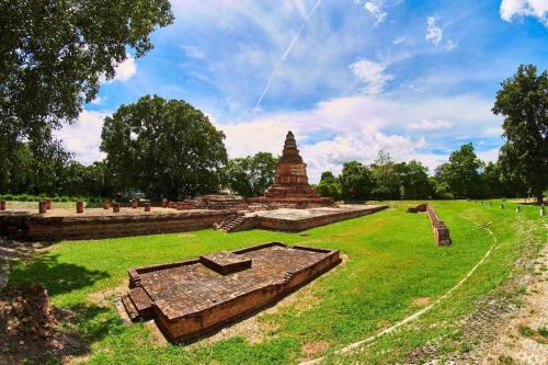 a large field with a pagoda in the background at OYO 412 7 Days Hotel in Chiang Mai