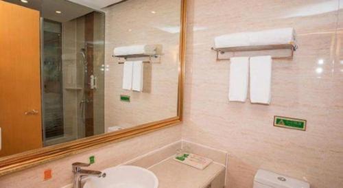 a bathroom with a sink and a mirror at Vienna Hotel Shenzhen Bao'an Airport Taoyuanju Pingluanshan Metro Station in Shenzhen