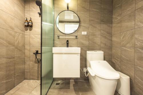 a bathroom with a toilet and a mirror at 樂居 台北 in T'ung-ko