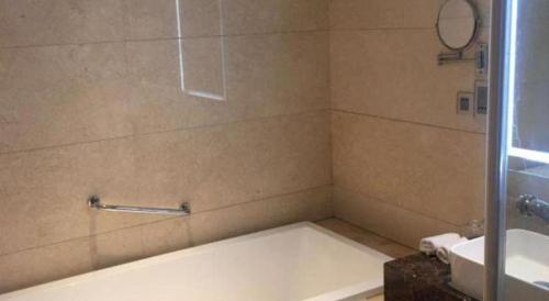 a bathroom with a bath tub and a sink at Datong Hotel in Datong