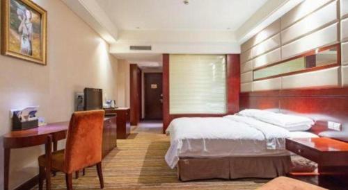a hotel room with a bed and a desk and a desk at Hohhot Hai Liang Plaza Hotel in Hohhot