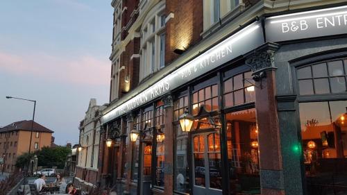 a building with a sign on the side of a street at OYO The Kilburn Arms in London