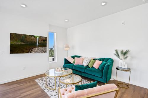 a living room with a green couch and a table at One Lux Stay - Hollywood in Los Angeles