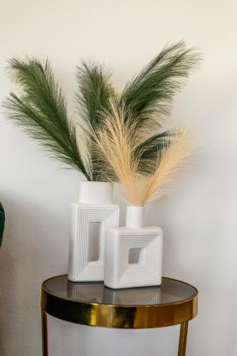 three white vases sitting on top of a table at One Lux Stay - Hollywood in Los Angeles
