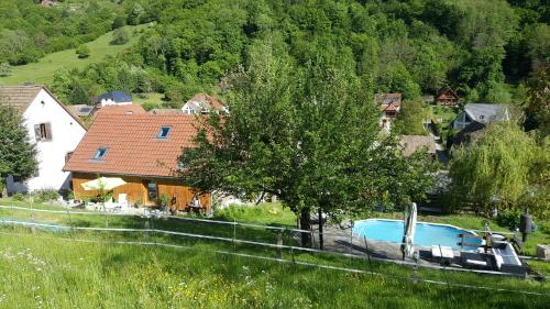une maison avec une piscine et un arbre dans l'établissement La Grange, à Lautenbachzell