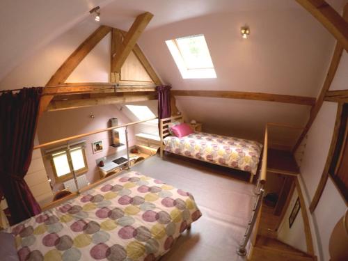 an attic bedroom with two beds and a window at La Grange in Lautenbachzell