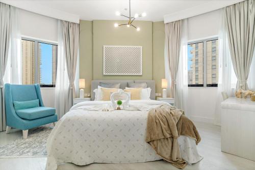 een slaapkamer met een bed en een blauwe stoel bij Burj View Downtown 1BR Dubai in Sabkhah