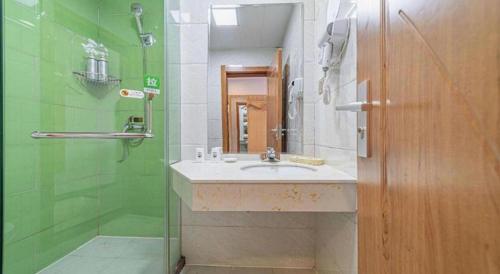 a bathroom with a sink and a shower at GreenTree Inn Haixi Geermu Southern suburbs Express Hotel in Golmud