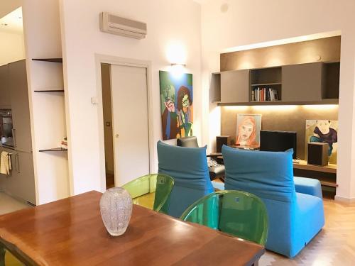 a living room with a table and blue chairs at Elegante in centro in Imola