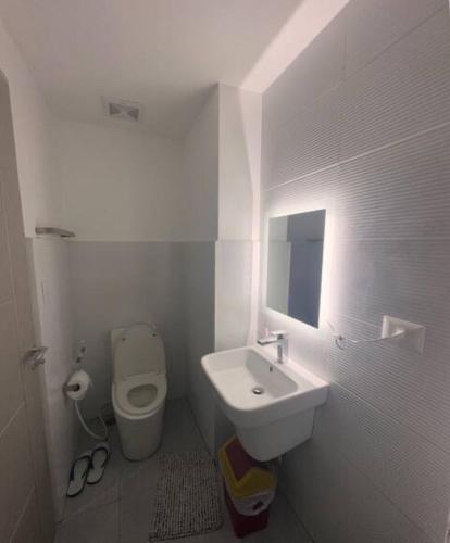 a white bathroom with a sink and a toilet at 6 beds condo unit in Bernwood Tower in Iloilo City
