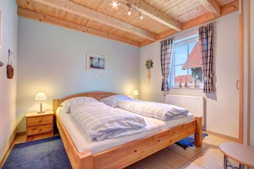 Schlafzimmer mit einem Bett und einem Fenster in der Unterkunft Paradies-Ferien in Burhave