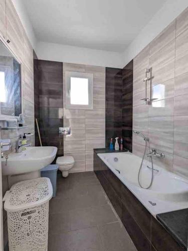 a bathroom with a tub and a sink and a toilet at Djerba apartments 2 in Bin Rhilouf