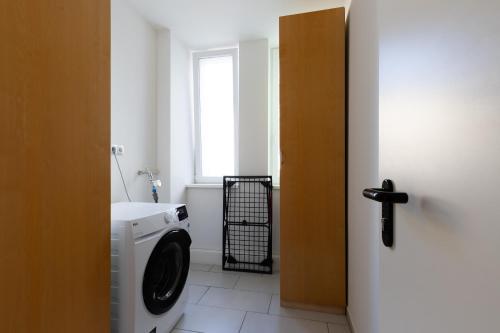 a bathroom with a washing machine and a window at Zentral gelegenes 3 BR Work&Soul Apartment, ideal zum Entspannen und Arbeiten in Neustadt an der Weinstraße