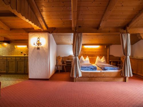 a bedroom with two beds in a room with wooden ceilings at Appartements Stadlerhof in Kramsach