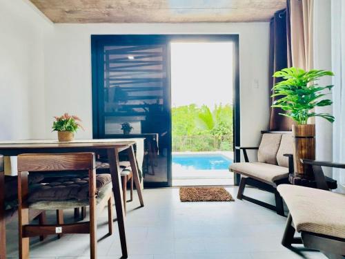 a dining room with a table and chairs and a pool at PRIVATE VILLA IN TAGAYTAY with PRIVATE POOL and Basketball Court LMN PLACE in Tagaytay