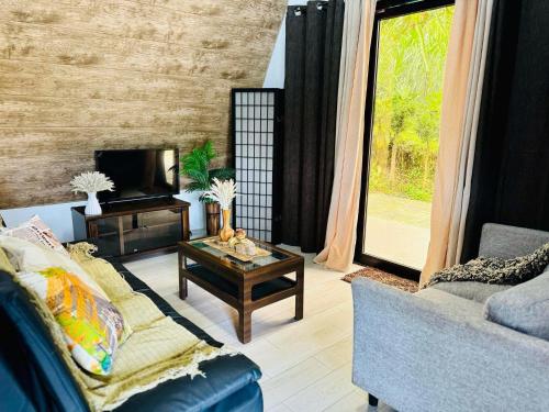 a living room with a couch and a coffee table at PRIVATE VILLA IN TAGAYTAY with PRIVATE POOL and Basketball Court LMN PLACE in Tagaytay