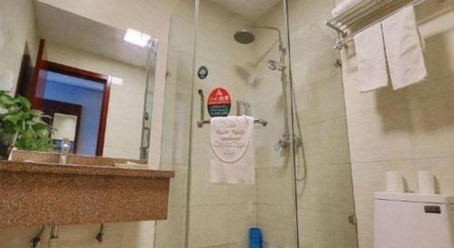 a bathroom with a shower and a sink and a mirror at GreenTree Inn Suzhou Shihu Suli Road Express Hotel in Suzhou