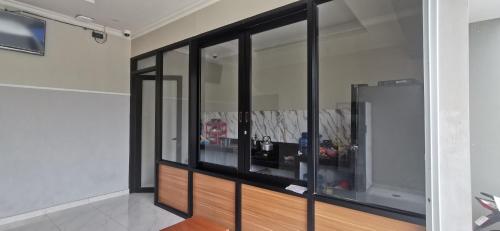 a room with glass windows in a room at Hotel O Madina Homestay in Samarinda