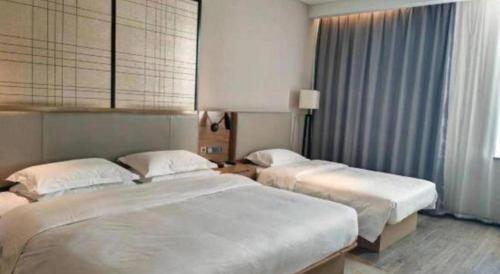Ένα ή περισσότερα κρεβάτια σε δωμάτιο στο Echarm Hotel Jinan Railway Station Daming Lake