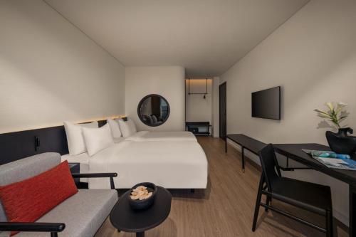 a hotel room with a large bed and a couch at Caro Premium Danang Hotel in Da Nang