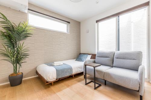 a bedroom with a bed and a couch and a plant at First Choice Minami Kamata in Tokyo