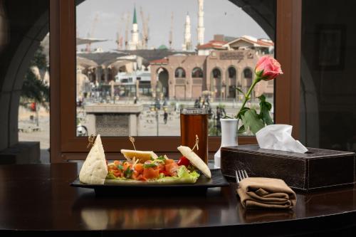 a table with a plate of food and a drink at Millennium Taiba Hotel in Al Madinah