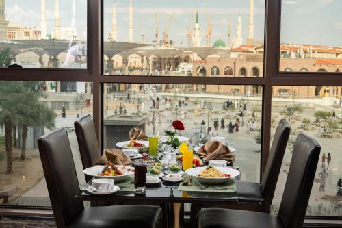 a table with food and a view of a city at Millennium Taiba Hotel in Al Madinah