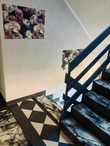 a staircase in a room with a painting on the wall at Pod Różą B&B in Ustka