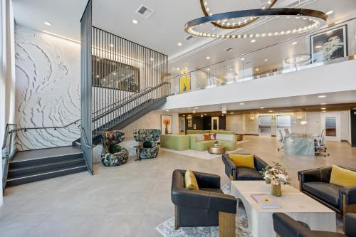 a lobby of a hotel with a staircase and couches at One Lux Stay - Hollywood in Los Angeles